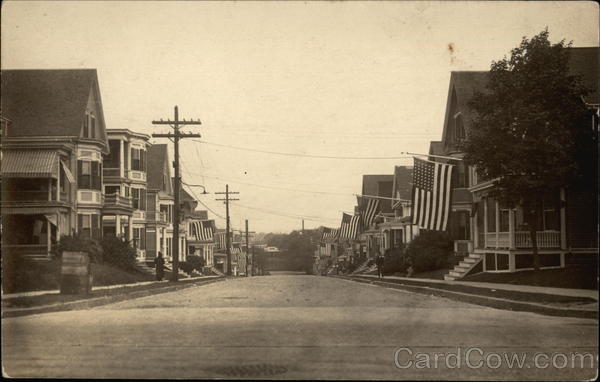View Down Residential Street with American Flags Hanging from Houses