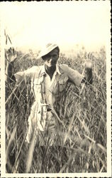 Man in hat in tall field Postcard