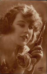 Beautiful Woman holding Rose while gazing into Hand Mirror Postcard