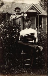 A Woman Pours Water On a Man Reading a Magazine Postcard