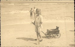 Two Children in the Ocean & One on the Beach with her Toys Postcard