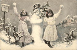 Two Girls Playing in the Snow beside a Snowman Postcard