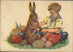 Little Boy in Red Shorts Holding Bunny's Paw Surrounded by Colored Easter Eggs Postcard