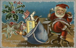 Santa talking on old telephone with blue bag of toys next to him Postcard