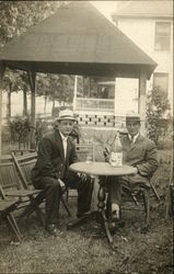Two men sitting at round table outside Two men sitting at round table outside