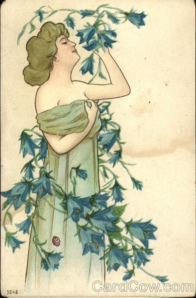 Woman in Long Green Gown Smelling Vine with Blue Flowers