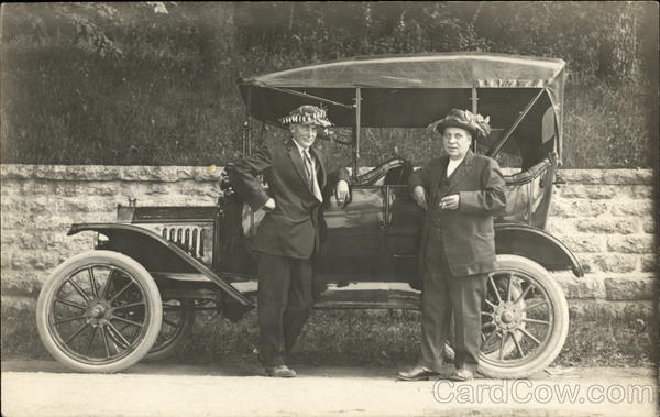 Two Men in Funny Hats Standing by Car Cars