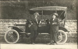 Two Men in Funny Hats Standing by Car Postcard