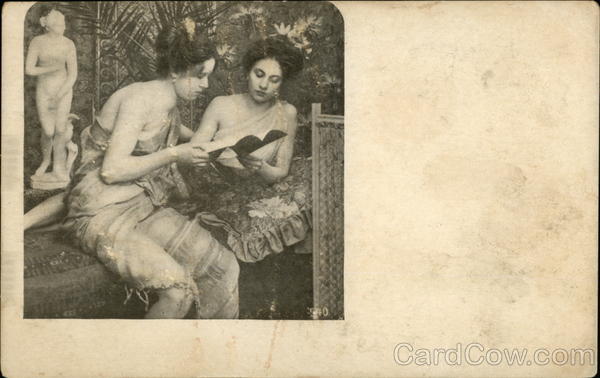 Two Women in Native Dress Reading Book