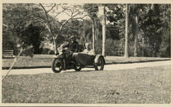 Men riding a motorcycle with a sidecar Postcard