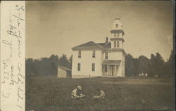 Children sitting in a meadow next to a church Postcard