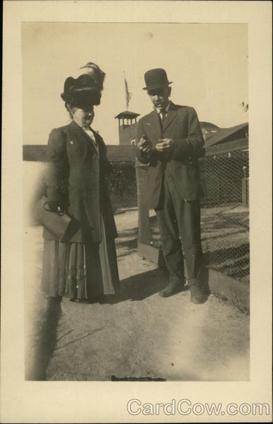 Couple Standing by Wire Fence, Woman with Large Hat California