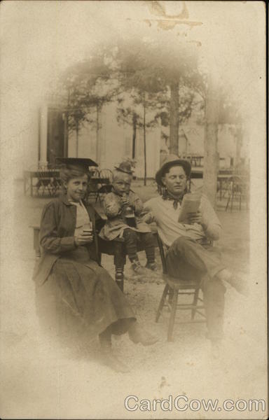 Family Portrait of Woman Graduate, Man Reading, and Child Holding a Drink