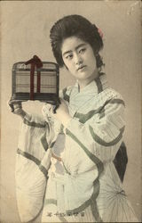 A Japanese woman holding a birdcage. Postcard