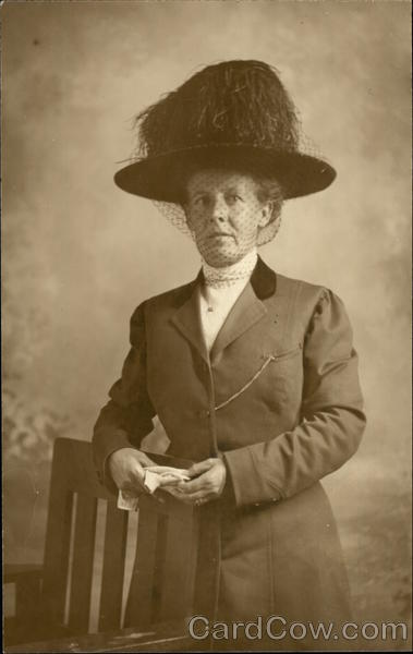 Woman in Large Hat Posing by a Chair Women