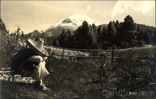 Man Sitting in a Country Field in front of a Mountain Mexico