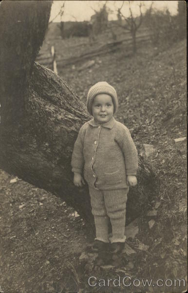 Child in Winter Attire Posing by a Tree Children