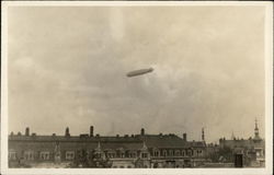 Blimp Flying High Above Buildings Postcard