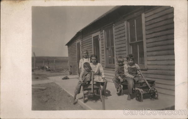 Children on the Back Porch in Toy Wagons