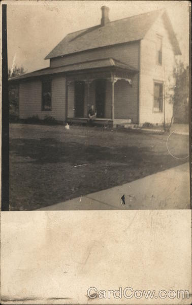 Man Sitting on Porch of Small House Kewanna Indiana