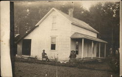 A man and a woman seated outside a house A man and a woman seated outside a house
