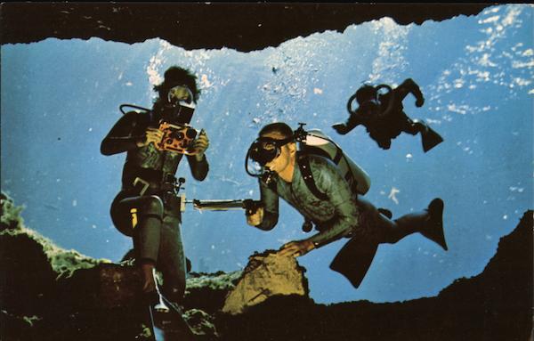 Divers demonstrate underwater scuba equipment in the crystal clear water of Florida Silver Springs