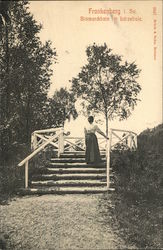 Black and White photo of a woman on stairs outside early 1900's German Postcard