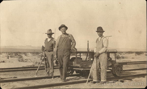 Three men building track for the railroad Circa 1900