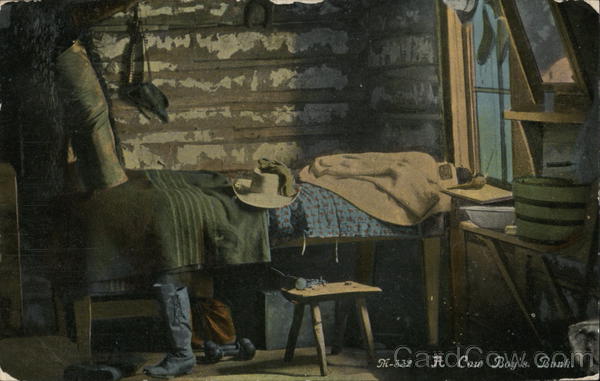 A cowboy's bunk - hat on a bed with boots next to it