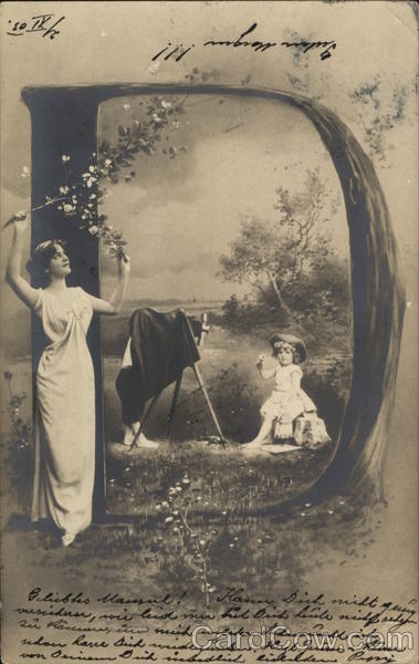 Woman photographing a child seated inside a large letter D