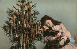 child hugging a doll in front of a Christmas tree Children Postcard Postcard Postcard