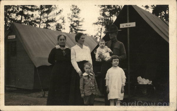 Soldier Posing with Family in front of Tents People in Uniform