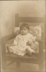 Baby Posing on a Chair with a Doll Baby Posing on a Chair with a Doll