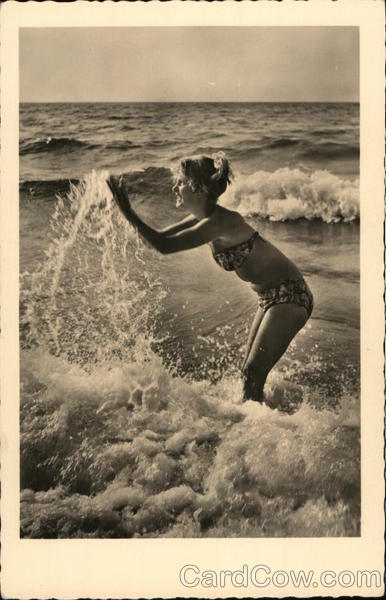 A Woman in a Bikini Plays in the Ocean Swimsuits & Pinup