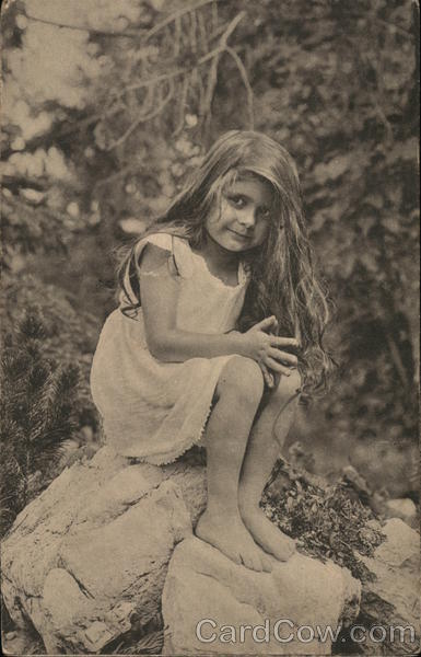 Young Girl with Long Hair Perched on a Rock Outdoors