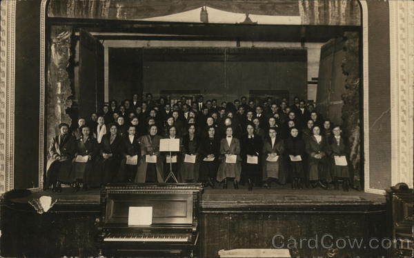 Large Choir in Multiple Rows on Stage Behind Piano