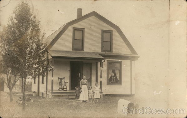 Mother and Three Young Children in Front of House