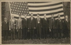 10 Men Lined Up, Standing in Front of American Flag Postcard