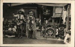 Two Indian People in Costumes With Arms Raised Near Others Two Indian People in Costumes With Arms Raised Near Others