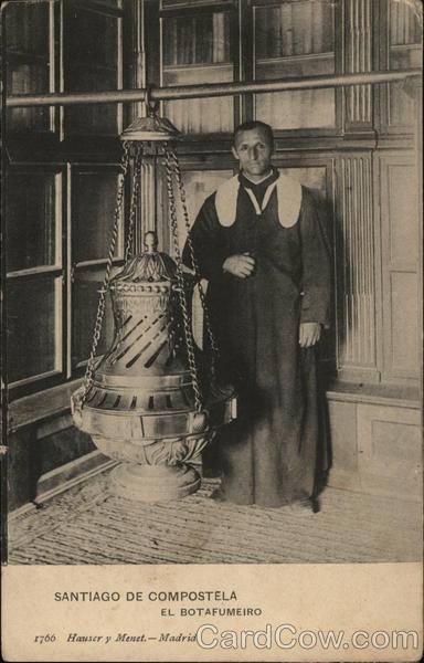 Man Dressed in Religious Garb Near Large Metal Artifact