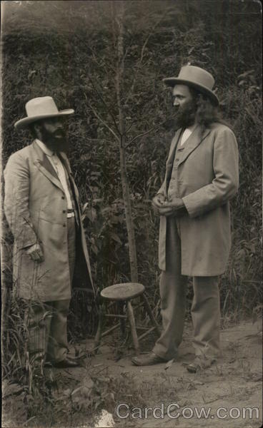 Two Men Wearing Hats and Long Suit Jackets Outdoors