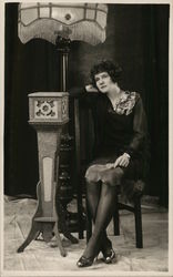 Woman Seated Near Ornate Lamp Postcard