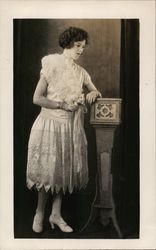 Woman in Frilly Dress Leaning on Podium Postcard