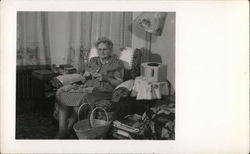 A Woman Sitting in a Chair Knitting Postcard