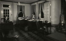 Three People Seated at Three Desks in Office Setting Postcard