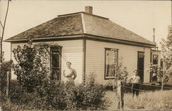Woman and Boy Standing in Yard Near House Woman and Boy Standing in Yard Near House