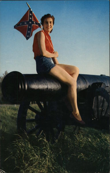 A Woman Sitting on a Canon Holding a Confederate Flag
