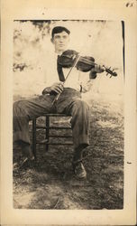 Man Seated Outdoors Playing Violin Postcard