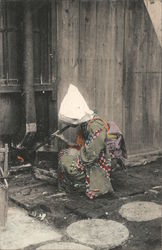 A lady lighting a fire Postcard