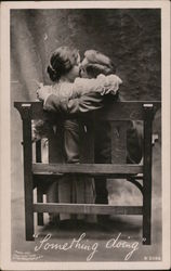 "Something Doing" - photo of couple kissing on bench Postcard